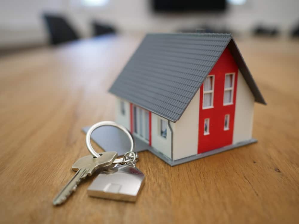 Llavero con forma de casa junto a un juego de llaves